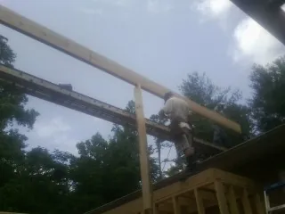 Carpenter setting a ridge beam over a new addition frame — Ice Dam Removal by Roofing Brothers in Dublin